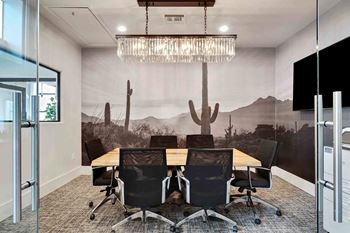 a conference room with a wooden table and chairs and a mural on the wall